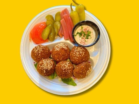 Six pieces of fried falafel with tahini sauce