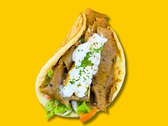 Gyro sandwich with lettuce, tomato, onion and tzatziki sauce
