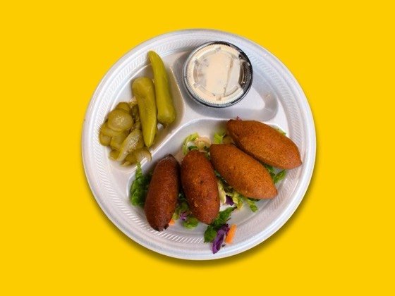 Four pieces of kibbeh, bulgur shells filled with ground beef and pine nuts
