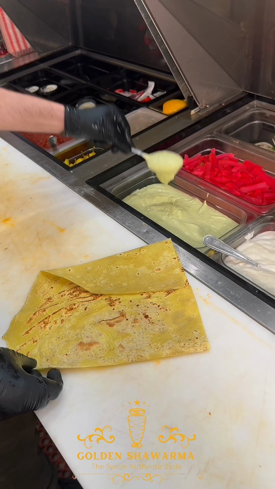 Paper-thin saj flatbread being cooked on a domed griddle