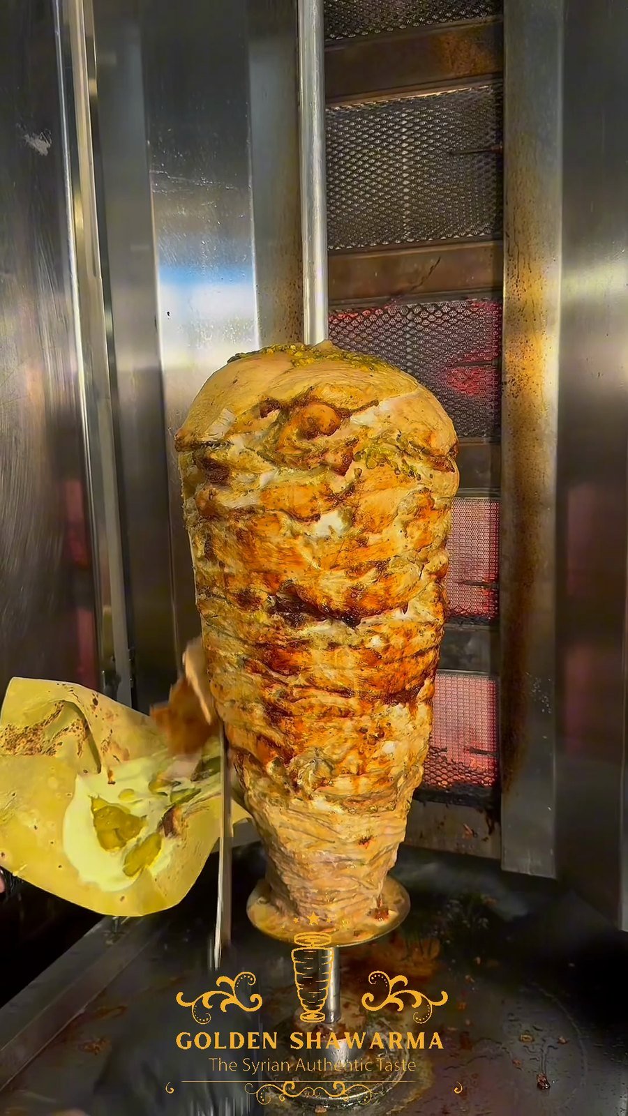 Golden chicken shawarma turning on the vertical rotisserie at Golden Shawarma in Richardson, TX